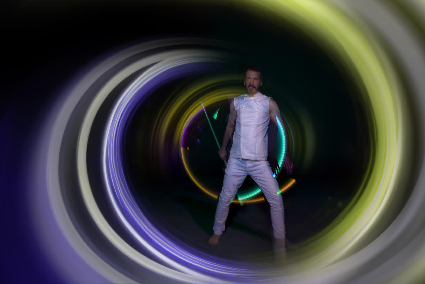 LED juggler drawing a circle of light in the air with colour-shifting props