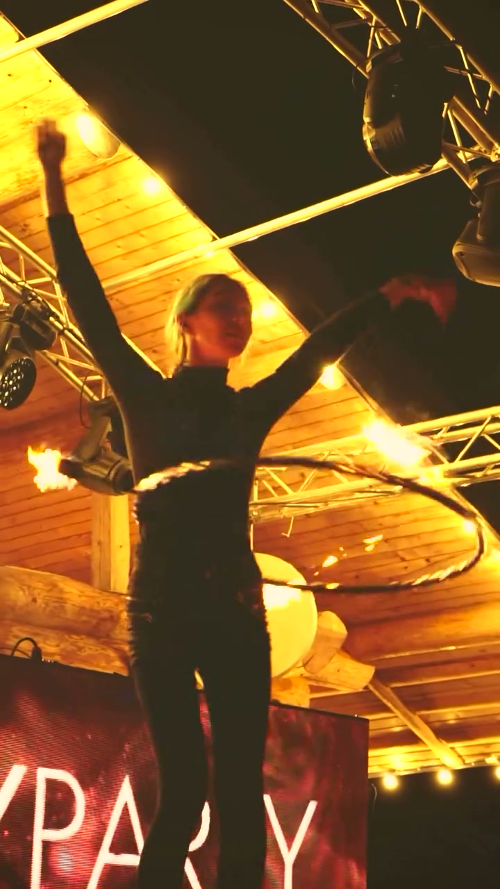Performer spinning a fire hoop on her waist at an event